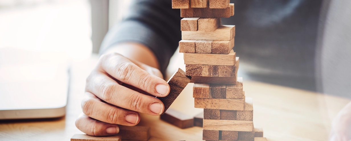 Man pulling a Jenga block out of the tower