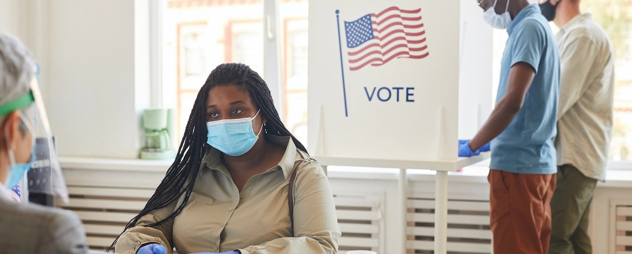 Image of people by a vote sign