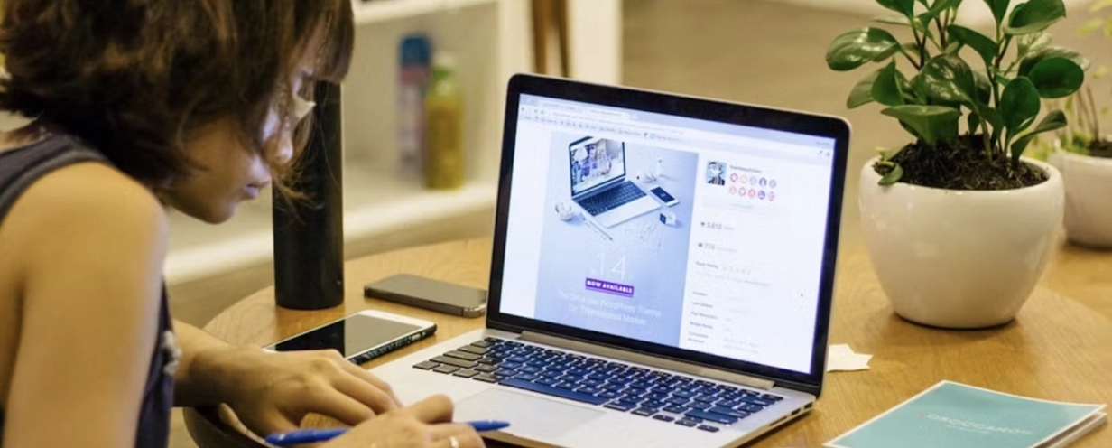 Image of woman bent over her laptop working