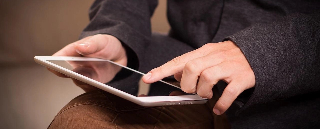 Photo of a person holding a laptop on their leg