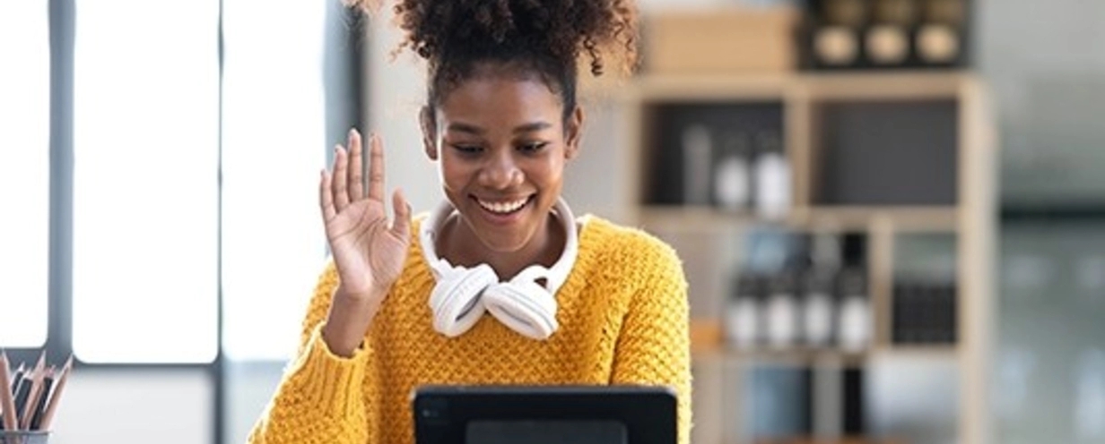 Person waving hello to someone on a zoom call