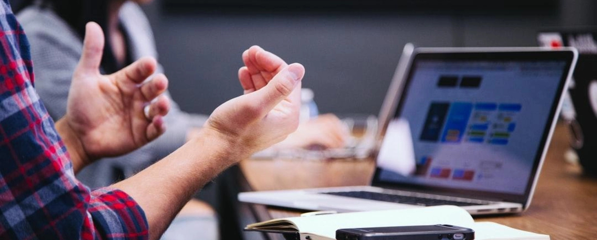 image of hands and talking in front of a laptop