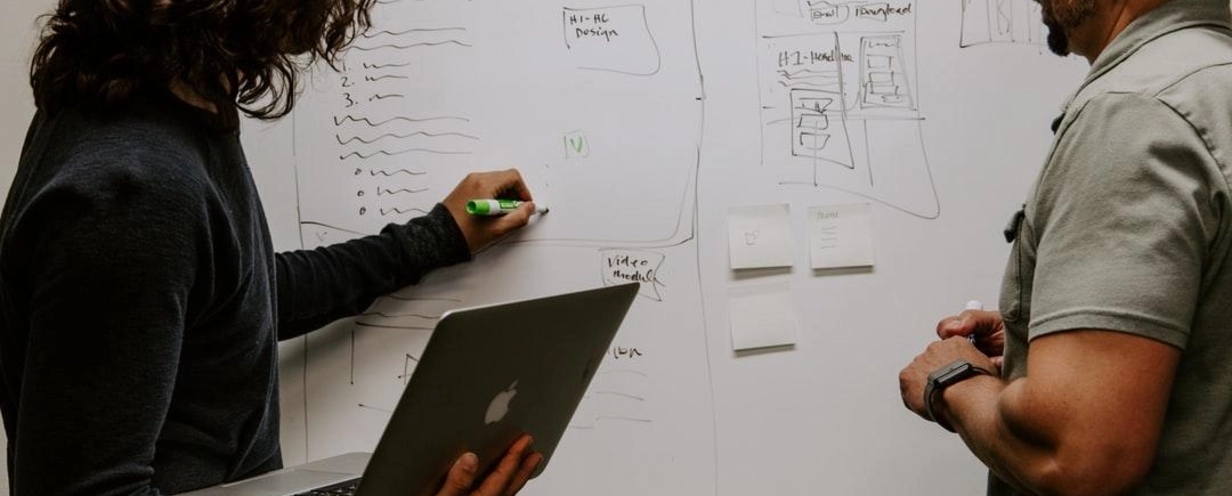 Man and woman writing on a whiteboard