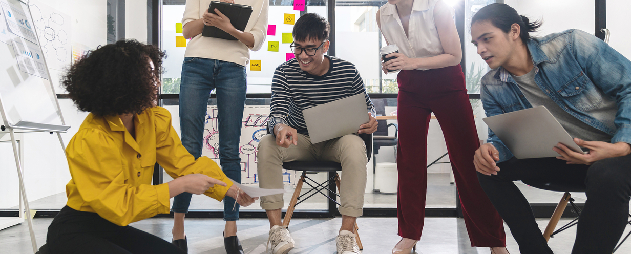 Group of individuals surrounding a business plan in an office