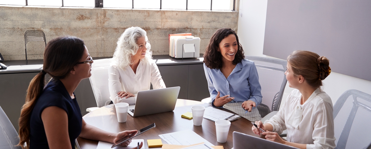 Photo of four business professionals meeting at a conference table