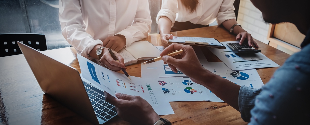 Photo of 3 people reviewing a marketing plan at a conference table