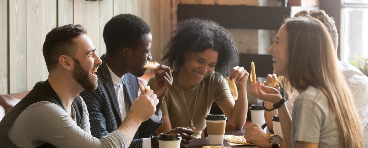 People laughing while sitting at a table with coffee