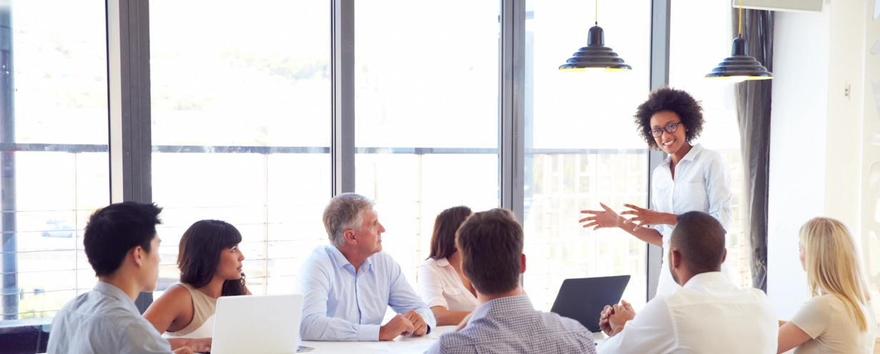 Photo of a group of business people seated in a meeting room for a presentation