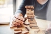 Man pulling a Jenga block out of the tower