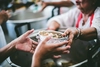 Photo of someone's hands reaching for a bowl of food