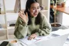 woman waving at laptop screen