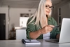 Photo of a person looking at their credit card while typing on their laptop