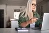 Photo of a person looking at their credit card while typing on their laptop