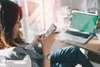 Woman sitting at desk looking at mobile phone