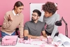 Three people talking to each other in a pink office