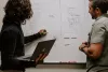 Man and woman writing on a whiteboard