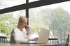 business professional talking on the phone while typing on laptop