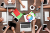 Photo of a group of designers huddled around a conference table looking at a color wheel