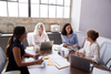 Photo of four business professionals meeting at a conference table