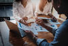 Photo of 3 people reviewing a marketing plan at a conference table