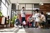 Team sitting in a circle and listening to talking woman holding her laptop