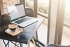 Photo of laptop and cup of coffee on a table