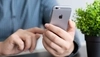 Photo of a businessperson's hands holding and tapping on their iPhone