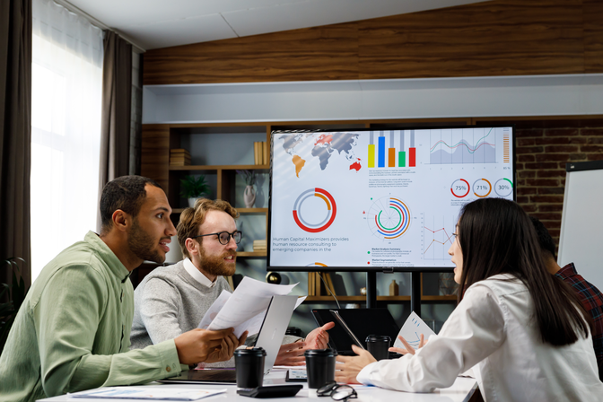 Team sitting at conference table in office reviewing conversion rates