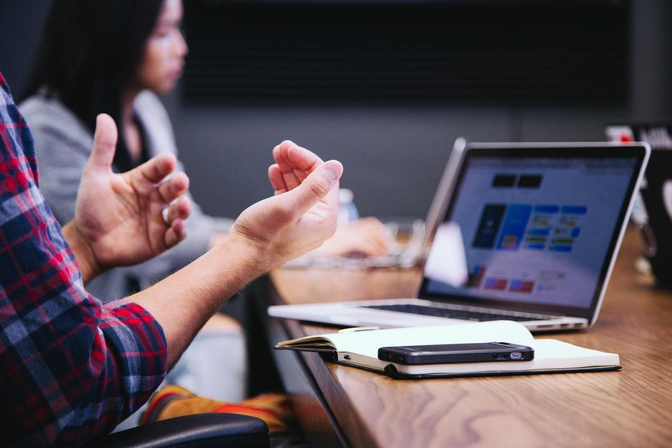 image of hands and talking in front of a laptop
