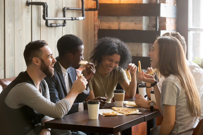 People laughing while sitting at a table with coffee