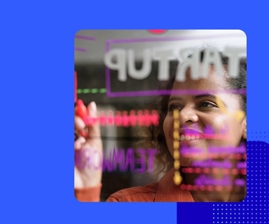 Image of a woman writing on a clear board viewed from the opposite side 