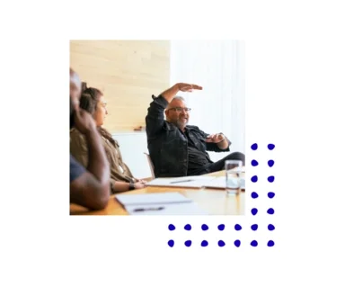 Photo showing a man at a conference table gesturing with his hands